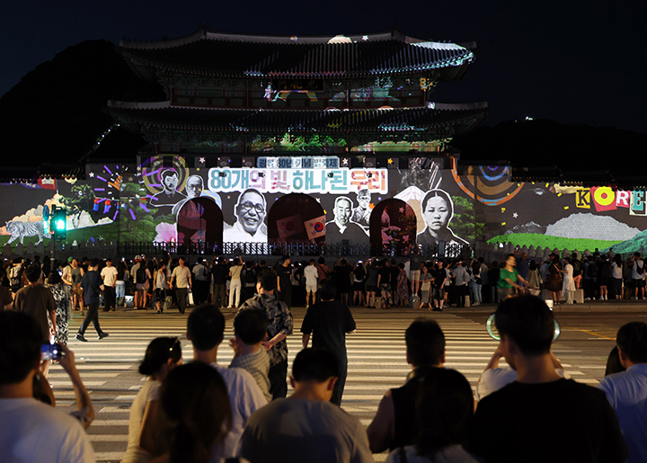 서울 광화문 앞에서 시민들이 광복 80년 빛 축제 '80개의 빛, 하나된 우리' 미디어 파사드 영상을 보고 있다. 2025.8.16 (ⓒ뉴스1, 무단 전재-재배포 금지)