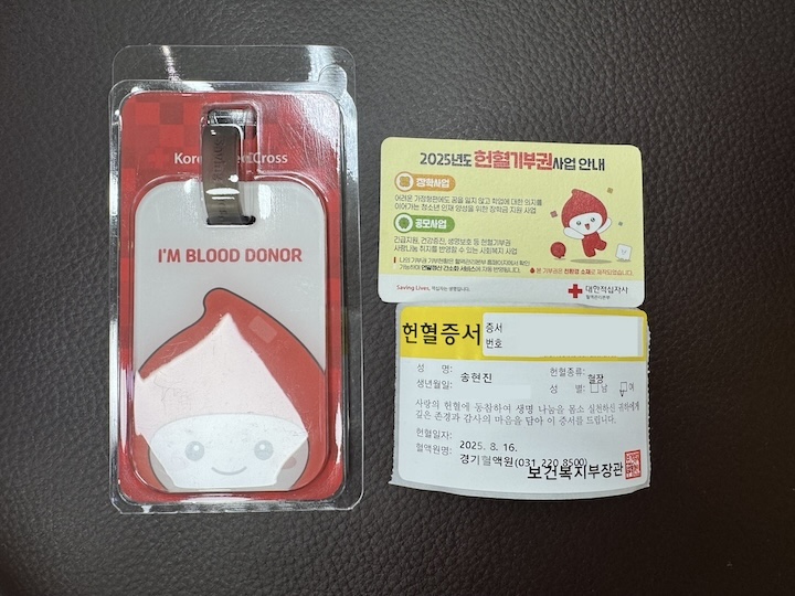 헌혈 후 받은 기념품. 첫 헌혈 기념 네임택과 선택 기념품인 기부권, 그리고 헌혈 증서를 받았다.