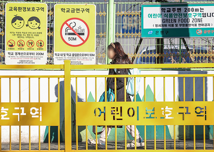 서울의 한 초등학교에 등교하는 어린이 위로 교육환경보호구역 및 어린이 식품안전보호구역 안내 표지판이 설치돼 있다. 2025.2.24 (ⓒ뉴스1, 무단 전재-재배포 금지)