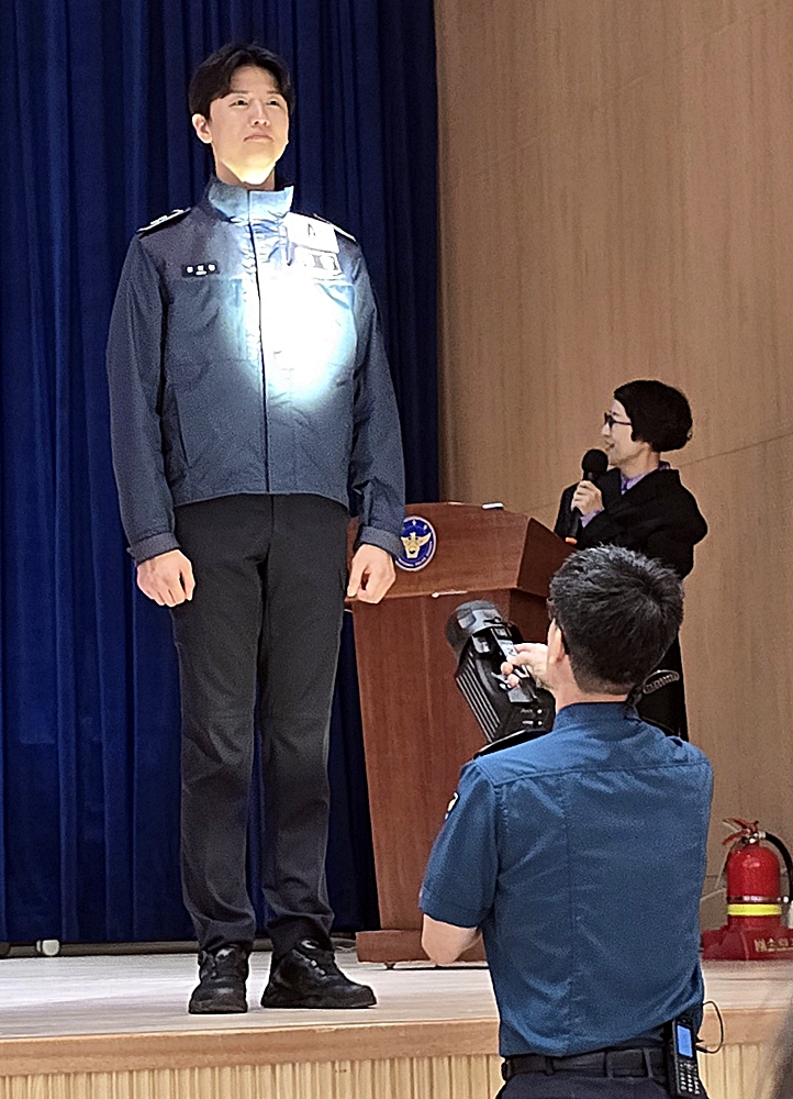 경찰청 담당자가 직접 손전등으로 재귀반사를 시험해 보이고 있다.