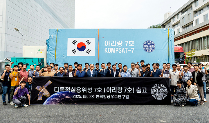 우주항공청과 한국항공우주연구원 관계자들이 23일 오전 발사준비를 위해 남미 기아나우주센터로 떠날 다목적실용위성 아리랑 7호 앞에서 기념촬영을 하고 있다.(사진=우주청 제공)