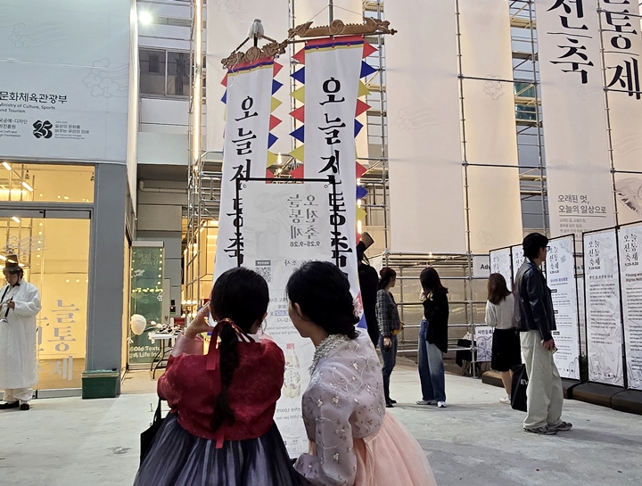한복을 입은 참관객이 정문에서 사진을 찍고 있다.