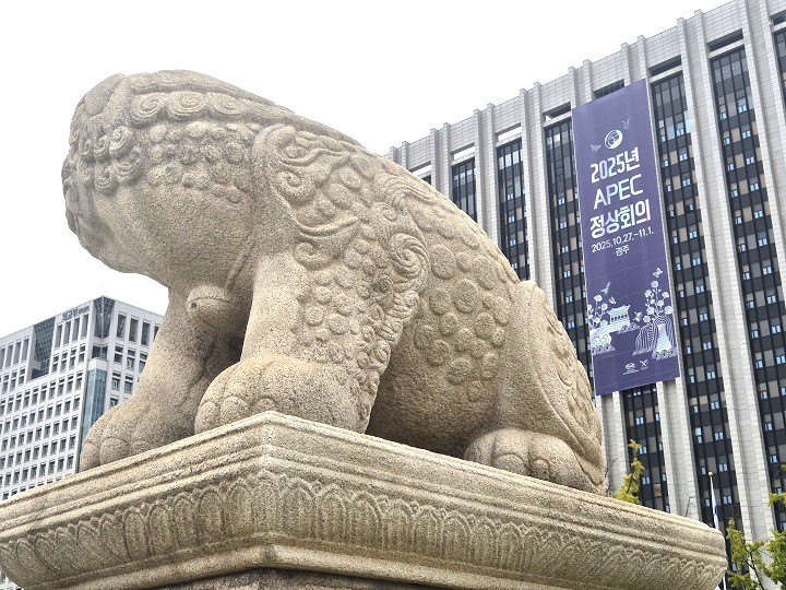 광화문 앞 해태상에서 바라보는 '2025년 APEC 정상회의' 홍보물.