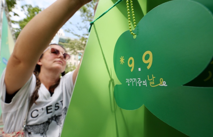 2025 서울시 장기기증의 날 행사를 찾은 한 외국인이 초록리본을 매달고 있다.(ⓒ뉴스1, 무단 전재-재배포 금지)