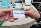 아버지가 '민생회복 소비쿠폰'으로 받은 선불카드를 식당 주인에게 건네주고 있다.