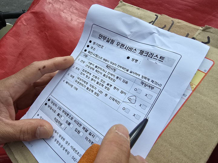 안부살핌 우편서비스 업무를 하며 확인 사항을 꼼꼼하게 체크한다.