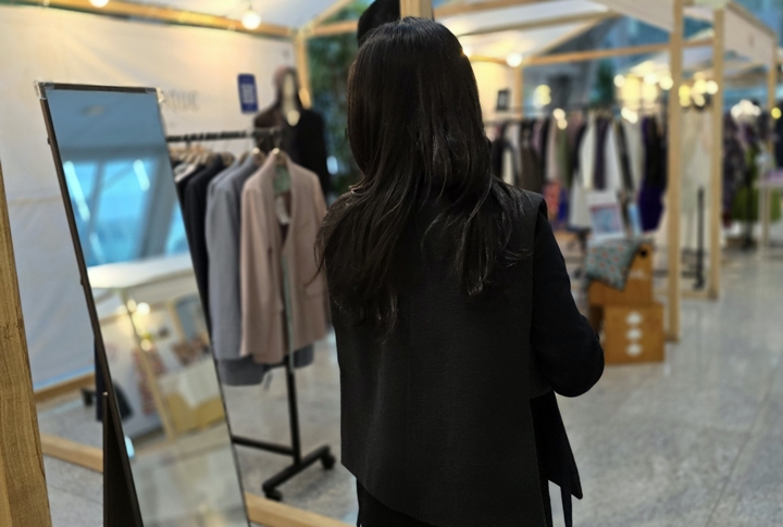 한복을 시착한 후 거울을 바라보고 있다.