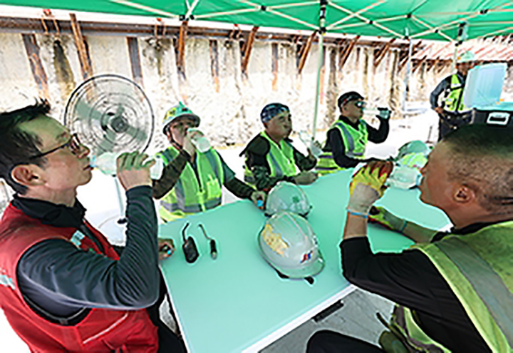 근로자 쉼터에서 무더위에 지친 근로자들이 선풍기 바람을 쐬며 물을 마시고 있다. (ⓒ뉴스1, 무단 전재-재배포 금지)