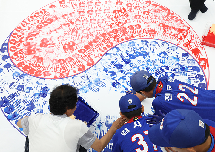 제80주년 광복절을 앞두고 경기 수원시 권선구청에서 구청 공무원 및 보훈단체 관계자, 권선구 리틀야구단 선수 등 참가자들이 손도장을 찍어 태극기를 만들고 있다. 2025.7.15 (ⓒ뉴스1, 무단 전재-재배포 금지)