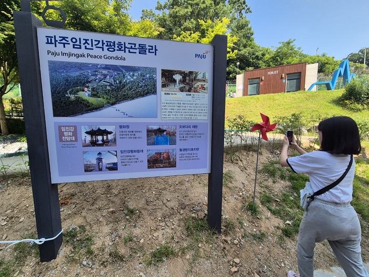파주 임진각 관광안내문을 사진에 담는 자녀.
