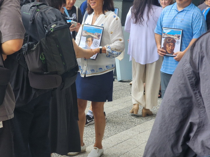 자신의 선조들 사진을 들고 내리는 후손들의 움직임.