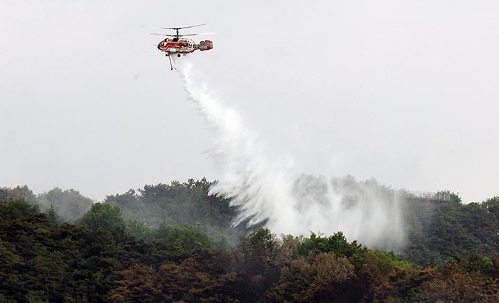 지난 5월 1일 대구 북구 함지산 산불이 재발화한 가운데 산림청, 소방 소속 헬기들이 진화작업을 하고 있다.(사진=저작권자(c) 연합뉴스, 무단 전재-재배포 금지)