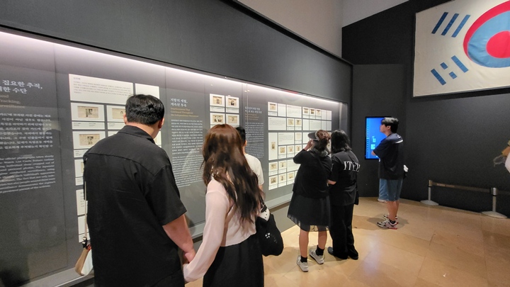 주요 감시 대상 인물 카드를 보고 있는 관람객들.