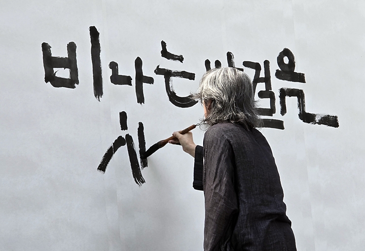 강병인 글씨 예술가가 무대에서 슬로건으로 퍼포먼스를 보이고 있다.