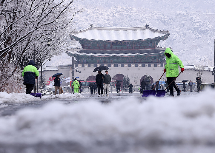 지난 3월 대설주의보가 발효된 서울 광화문광장에서 관계자들이 눈을 치우고 있다. 2025.3.18 (ⓒ뉴스1, 무단 전재-재배포 금지)