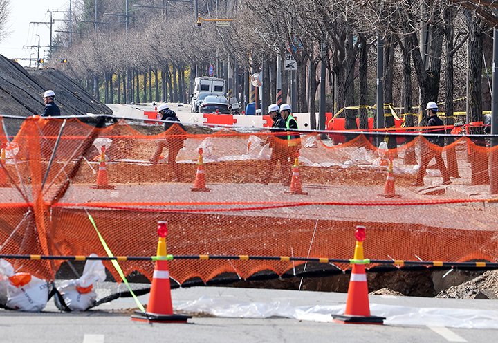 싱크홀(땅 꺼짐) 사고가 발생한 서울 강동구 명일동 대명초등학교 인근 사거리에서 서울 아리수 본부 관계자들이 사고 현장을 둘러보고 있다. 2025.3.31 (ⓒ뉴스1, 무단 전재-재배포 금지)