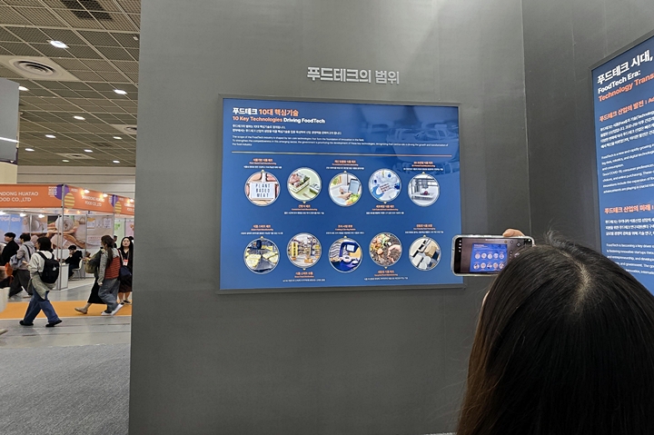 한 참관객이 푸드테크 핵심기술 10가지를 사진 찍고 있다.