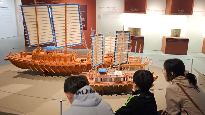 통신사선을 유심히 관찰하는 아이와 함께 온 관람객.