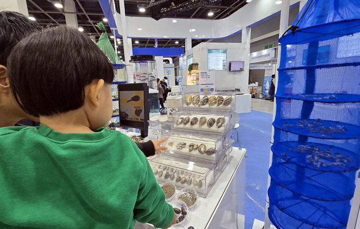 아이가 수산물을 바라보고 있다.