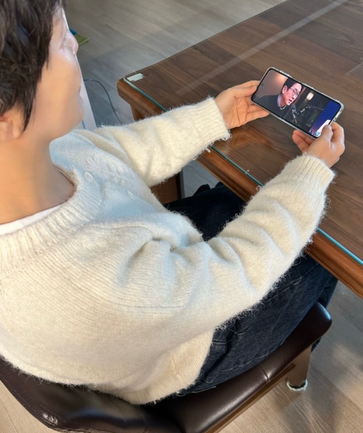 생성형 AI가 만든 가짜 전문가 영상을 시청 중인 어머니.