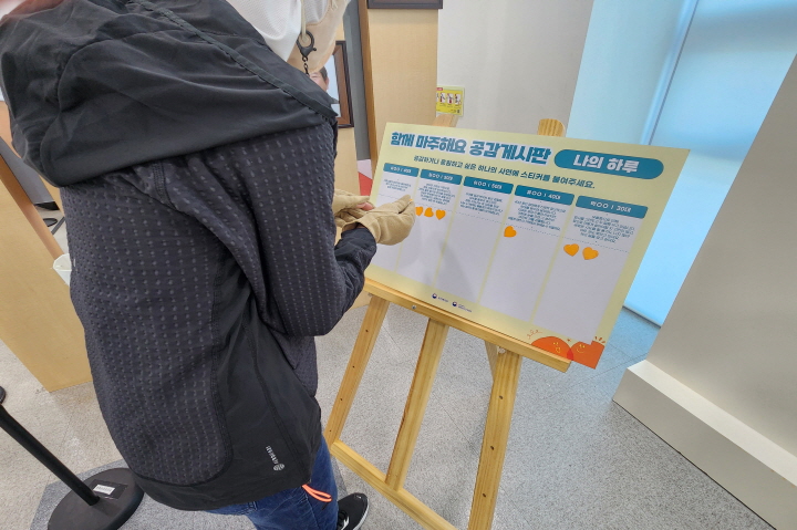 참가자가 '함께 마주해요, 공감 게시판'의 사연을 읽고, 공감·응원하고 싶은 글에 투표하고 있다.