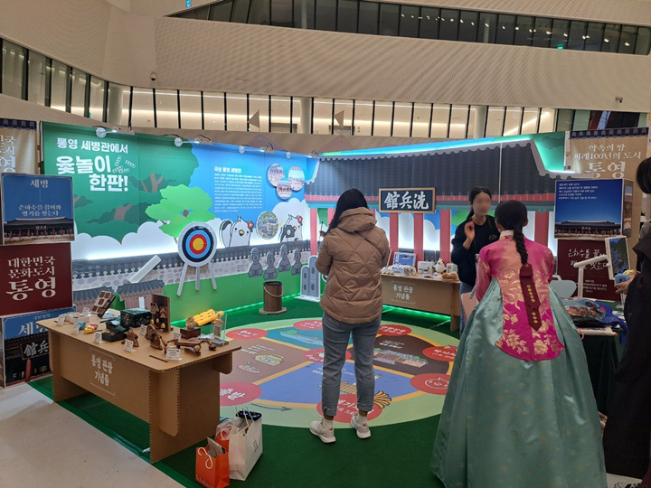 관람객들이 이벤트 공간에서 윷놀이를 즐기고 있다.