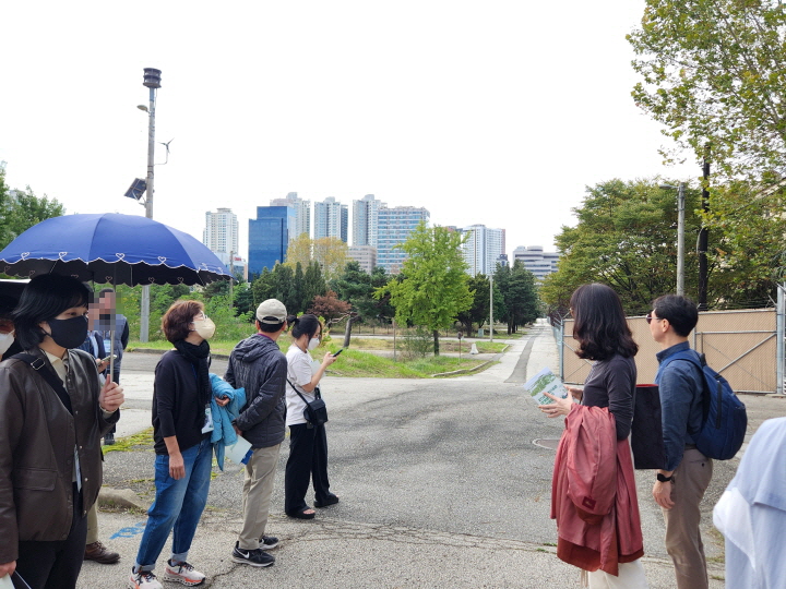용산기지는 서울의 고도를 보존하고 있다. 참가자들이 내리막길을 보고 있다.