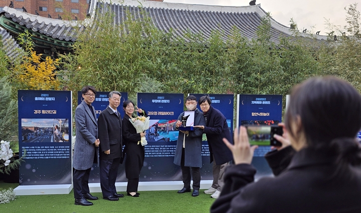 비가 그친 후 관계자들이 야외에 마련된 선정한 관광지 소개판에서 사진을 찍고 있다.