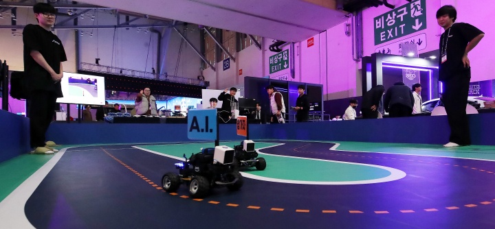 부산 해운대구 벡스코 제1전시장에서 열린 '제2회 코-쇼(CO-SHOW)'에서 관람객들이 인공지능(AI)과 인간이 운전 대결을 펼치는 자율주행 체험을 하고 있다. 2025.11.26. (ⓒ뉴스1, 무단 전재-재배포 금지)