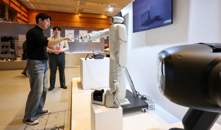 서울 강남구 코엑스에서 열린 디자인코리아 2025를 찾은 한 관람객이 홍익대 산업디자인과 제품경험디자인랩 '헤이테이트'가 디자인한 AI휴머노이드 로봇 '알프레드'와 인사하고 있다. 2025.11.12. (ⓒ뉴스1, 무단 전재-재배포 금지)