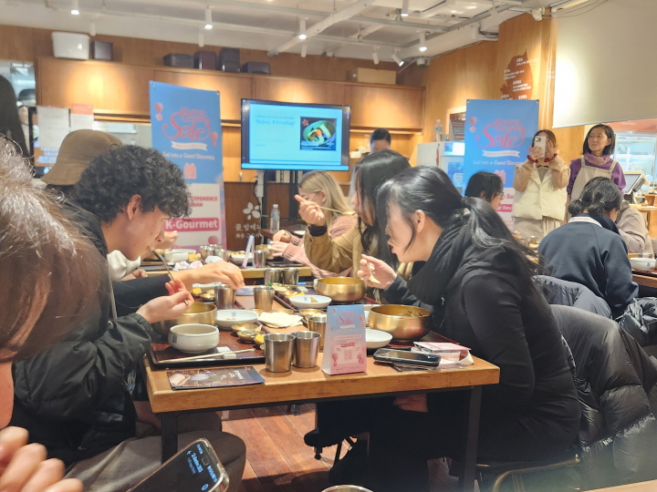 외국인들이 보자기 비빔밥을 만든 후 각자가 요리한 음식을 맛있게 먹고 있다.