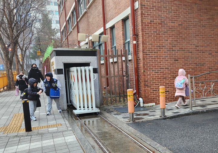 얼어있는 길을 걷는 아이들.