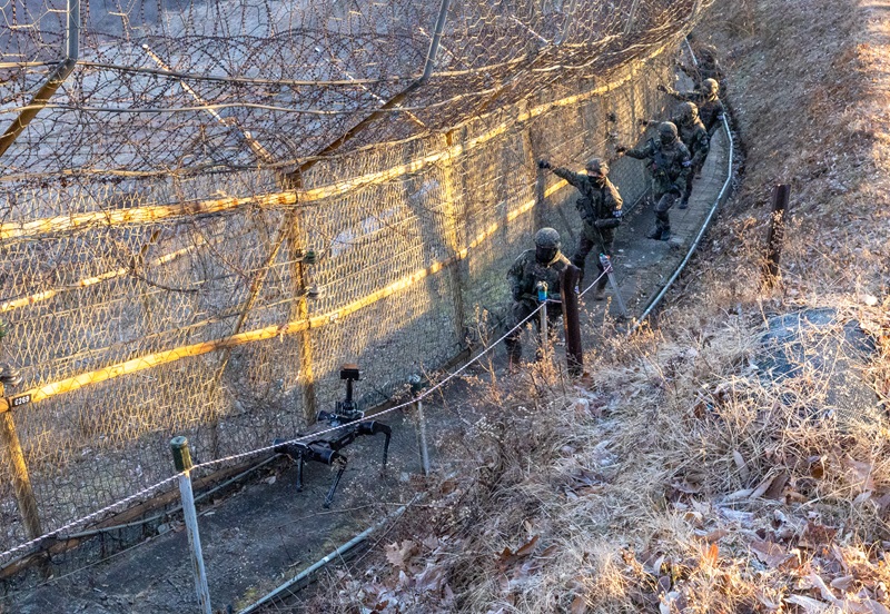5사단 열쇠부대 군 장병들이 지난 22일 경기 연천군 접경지역에서 시범 운용 중인 다족 보행 로봇과 함께 철책 경계 근무를 하고 있다.2025.12.29(사진=저작권자(c) 연합뉴스, 무단 전재-재배포 금지)