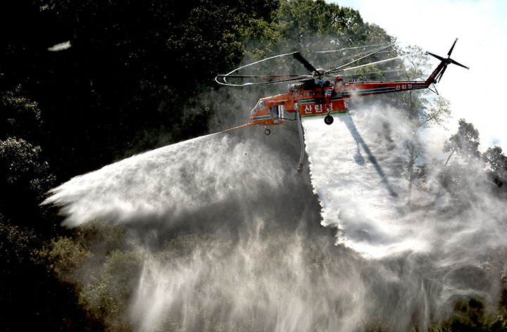 22일 충남 공주시 공산성 일대에서 열린 2025년 산불진화 통합훈련에서 헬기가 투입돼 공중 진화 시범을 보이고 있다. 2025.10.22 (사진=저작권자(c) 연합뉴스, 무단 전재-재배포 금지)