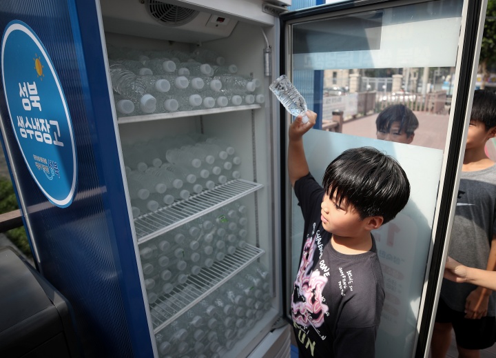 서울 성북구 바람마당에 설치된 '생수 나눔 냉장고'에서 학생들이 무라벨 생수를 꺼내고 있다.2024.7.14. (ⓒ뉴스1, 무단 전재-재배포 금지)