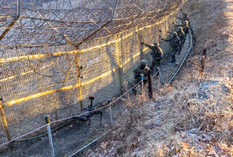 5사단 열쇠부대 군 장병들이 경기 연천군 접경지역에서 시범 운용 중인 다족 보행 로봇과 함께 철책 경계 근무를 하고 있다. 2025.12.29 (사진=저작권자(c) 연합뉴스, 무단 전재-재배포 금지)