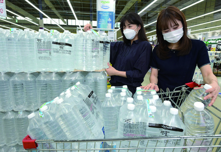 서울 서초구 농협 하나로마트 양재점에서 직원들이 재활용이 쉬운 '무라벨 생수'를 소개하고 있다.