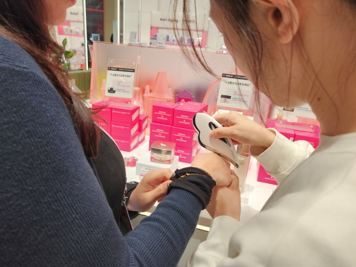 '케이-스타일리쉬(K-stylish)' 체험 프로그램에 참가한 외국인들이 매장에서 직접 자신의 피부에 적합한 화장품을 발라보고 있다.