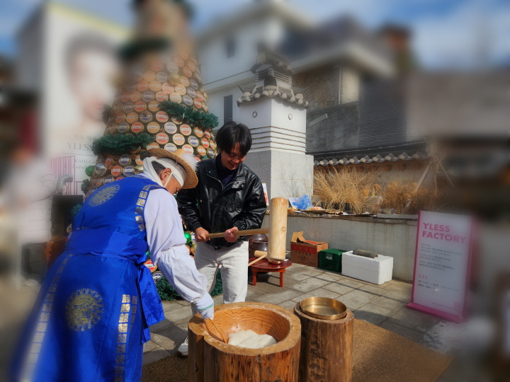 K-스타일리시 체험 프로그램이 열렸던 와이레스 북촌 플래그십 스토어 앞에서 떡메치기 체험을 하자, 행인들이 모여들고 있다.