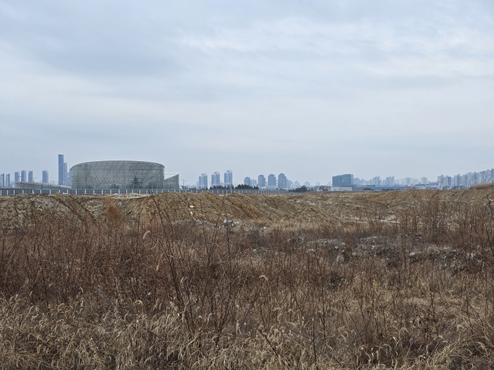 국립세종수목원 온실동을 배경으로 국회 세종의사당 부지가 광활하게 펼쳐져 있다.