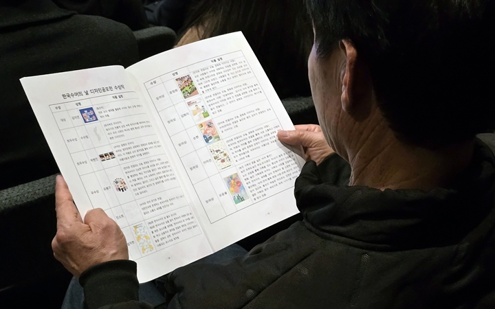 객석에서 자료를 유심히 바라보고 있다.