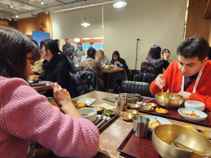 '2026 코리아그랜드세일' 기간 보자기비빔밥 체험 행사 현장에서 이탈리아 국적의 남매 안드레아와 사라가 직접 만든 보자기비빔밥을 먹고 있다.
