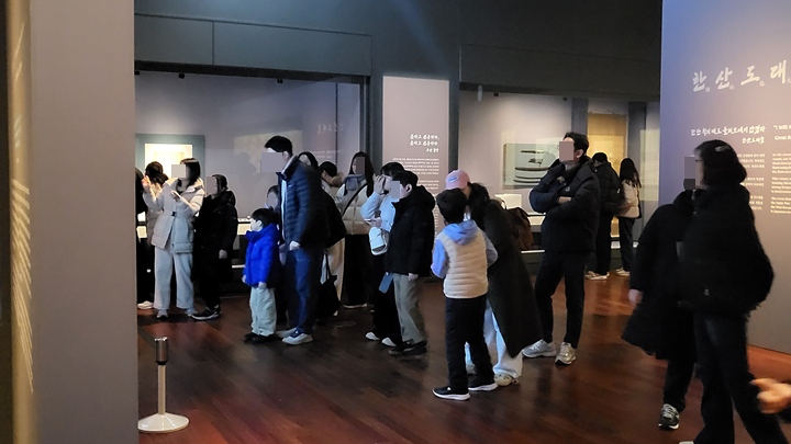 많은 관람객들이 거북선에 대한 설명과 복원된 거북선의 모습을 살펴보고 있다.