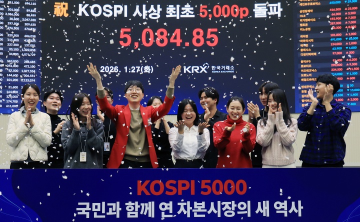 한국 증시 최초로 종가 기준 코스피 5000을 달성한 27일 서울 영등포구 한국거래소에서 직원들이 코스피 종가가 표시된 전광판을 배경으로 세레머니를 하고 있다. 2026.1.27 (ⓒ뉴스1, 무단 전재-재배포 금지)