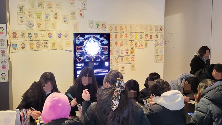많은 관람객들이 참여형 전시를 위해 자신만의 그림을 그리고 있다.