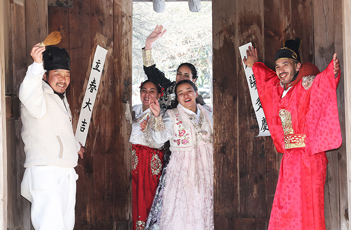 입춘을 이틀 앞둔 지난 2일 경기도 용인시 한국민속촌에서 외국인 관광객들이 어르신과 입춘첩을 붙이고 있다.(사진=저작권자(c) 연합뉴스, 무단 전재-재배포 금지)