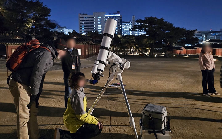 프랑스에서 온 가족들이 천체망원경으로 달과 목성을 보고 있다.