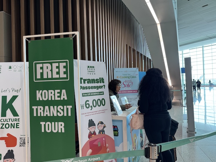 환승 편의시설 부근  K-Culture Zone에서 어떻게 체험을 할 수 있는지 물어보는 외국인 관광객의 모습.