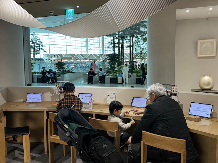 전통 장신구 만들기 체험을 하고 있는 한 어르신과 손자들의 모습.