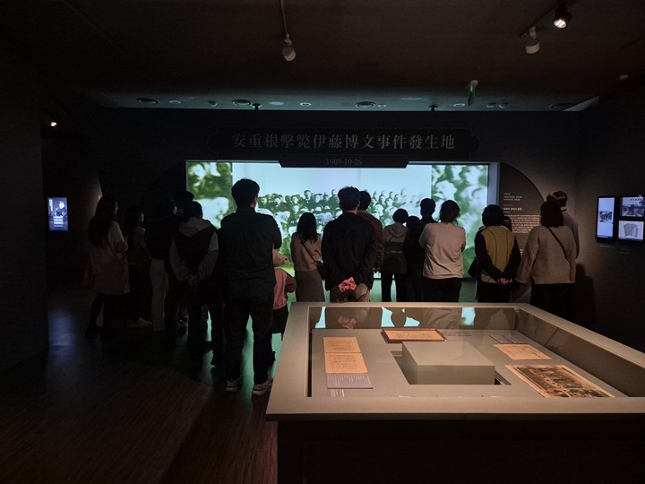 안중근 의사의 하얼빈 의거 영상 장면을 시청하는 수많은 관람객.